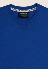 Felpa in cotone blu con collo rotondo, vestibilità ampia e polsini a costine. Include una banda con logo all'interno del colletto.