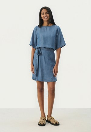 Denim dress featuring a loose-fit top, short sleeves, belted waist, and a slightly flared skirt. Light blue color with a soft texture.