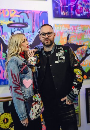 Denim jacket with embroidered details, including a heart and "love." Black bomber jacket with colorful cartoon patches. Printed crossbody bag.