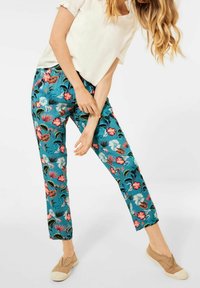 Blumenmuster-Hosen in Türkis mit rosa und weißen Blumen. Hergestellt aus leichtem Stoff, mit geradem Bein und knöchellanger Passform.