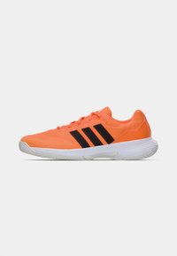 Πορτοκαλί αθλητικά παπούτσια με μαύρο σχέδιο τριών ρίγων, κλείσιμο με κορδόνια και λευκή λαστιχένια σόλα, με υλικό επάνω μέρος με υφή.