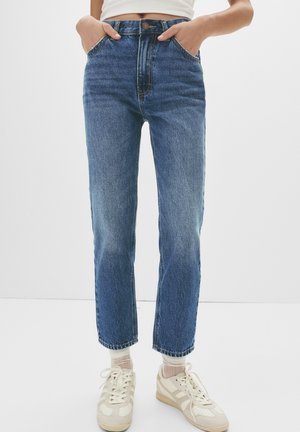 Hoge taille blauwe denim jeans met een rechte pijp, voorzien van een knoopsluiting, voorzakken en subtiele vervaging langs de dijen.