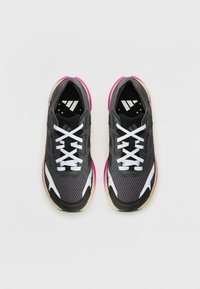 Sport shoes with a black mesh upper, white laces, and pink accents on the soles. Features a gray midsole and textured black panels.