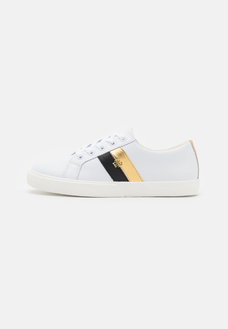 Witte low-top sneakers met witte veters, zwarte en gouden zijstreepjes en een rubberen zool op een effen witte achtergrond.