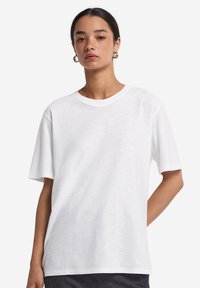 Hvid kortærmet t-shirt lavet af letvægts bomuld, med rund halsudskæring og en afslappet pasform med en let struktureret finish.
