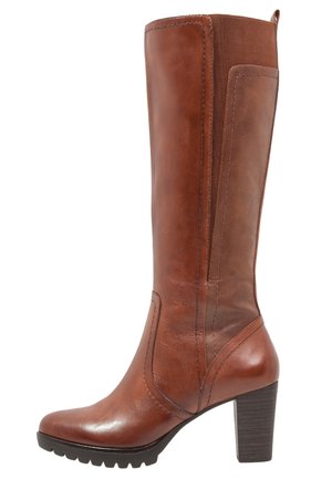 Botte en cuir marron jusqu'au genou avec un talon épais, texture lisse, détails de couture verticale et panneau latéral élastique pour plus d'élasticité.