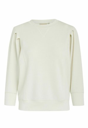 Gaišs bežs džemperis ar garām piedurknēm, nolaišanas pleciem un ribotām aprocēm. Iezīmē apaļu kaklu un smalkas šuvju detaļas uz pleciem.