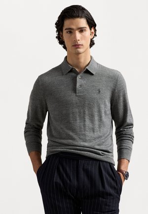Polo shirt gris à manches longues avec un col et trois boutons. Présente un logo discret et une texture lisse. Accompagné de pantalons à rayures fines sombres.