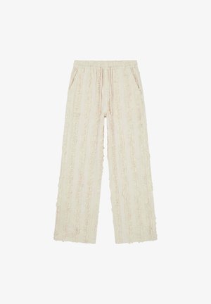 Pantalon ample couleur crème avec des rayures texturées verticales, taille élastique avec cordon de serrage, doté de poches latérales.