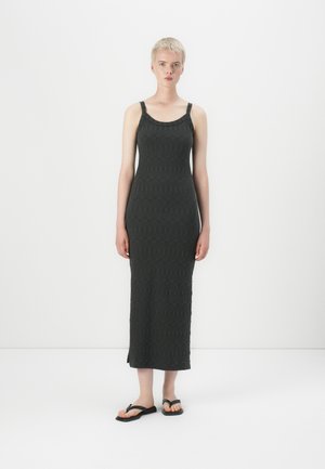 Maxi dress in dark gray knit fabric with a textured geometric pattern, featuring wide straps, a scoop neckline, and side slits.