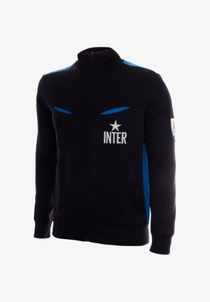 Zwarte jas met volledige ritssluiting, blauwe schouderstrepen, "INTER" tekst en sterlogo op de borst, en een patch op de rechtermouw.