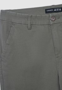 Chino in cotone verde oliva con chiusura a bottone, passanti per cintura e tasche laterali. Texture liscia con un design pulito e sartoriale.