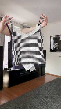 Top a righe blu navy e bianco, con pizzo lungo il collo, spalline sottili e vestibilità ampia. Include un'etichetta attaccata.