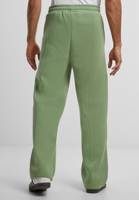 Lichtgroene sweatpants met een zachte textuur, elastische tailleband en rechte pijpen. Zichtbare naden en een relaxte pasvorm.