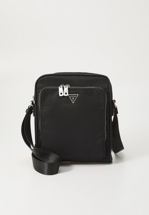 Geanta neagră din nailon tip crossbody are o formă plată, accesorii din metal argintiu, două fermoare și un logo triangular pe față. Include o curea ajustabilă.