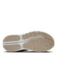 Semelle de chaussure présentant une surface en caoutchouc texturée avec des crampons proéminents pour une bonne adhérence. La palette de couleurs comprend du beige et du blanc avec des détails de marque.