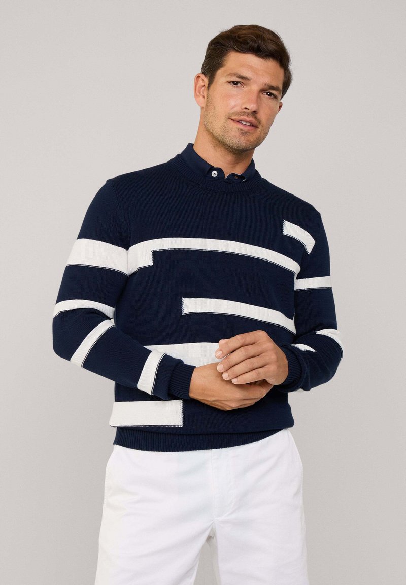Maglione a maglia blu navy con ampie strisce bianche e dettagli a maglia a contrasto. Presenta un collo a giro e polsini e orlo a coste.
