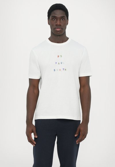 White cotton T-shirt featuring multicolored "PS Paul Smith" text on the front and back. Short sleeves, crew neck, relaxed fit.