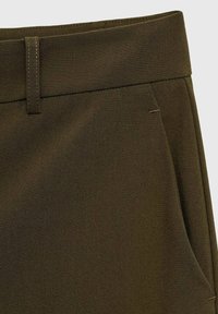 Hnědé látkové kalhoty s hladkou strukturou, slim fit a bočními kapsami s minimalistickými švy.