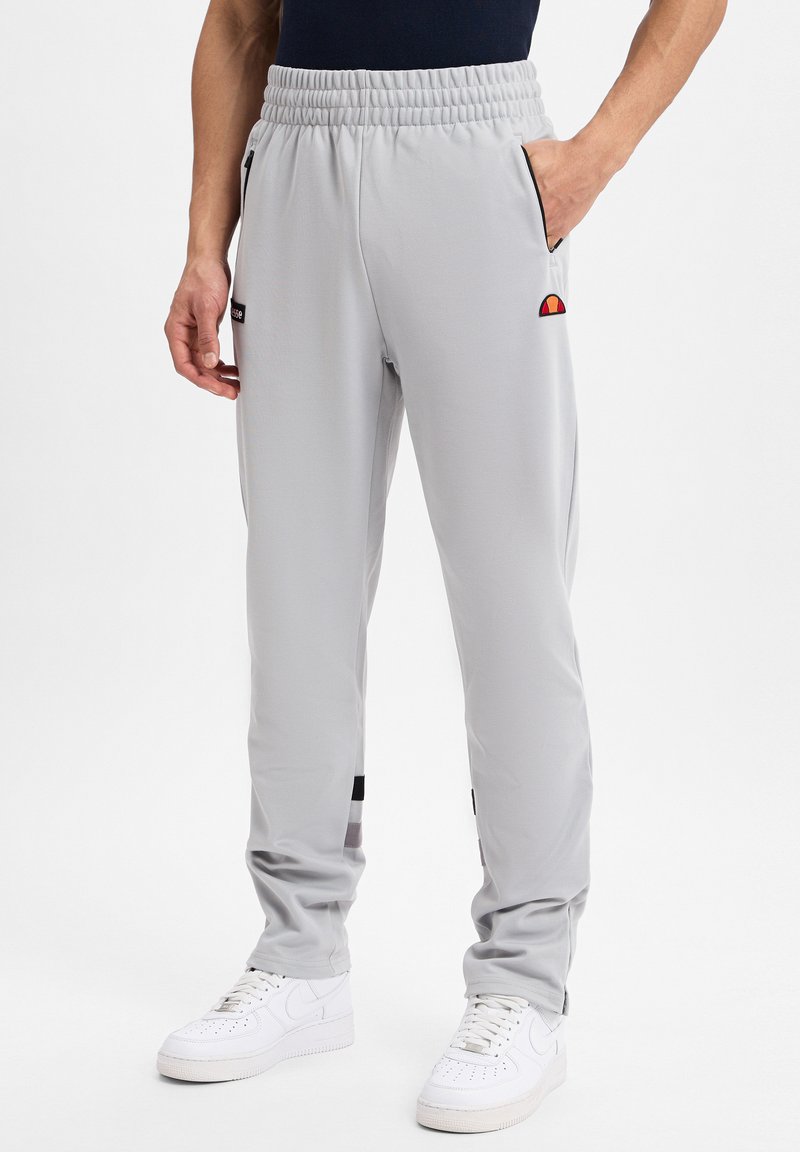 Helle graue Sporthose mit einem elastischen Bund, seitlichen Taschen und schwarzen Akzenten. Verfügt über ein kleines, farbenfrohes Logo in der Nähe der Tasche.