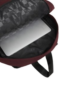 Mochila burdeos con una apertura con cremallera, que presenta un interior de patrón a cuadros negro y una laptop plateada descansando en su interior.