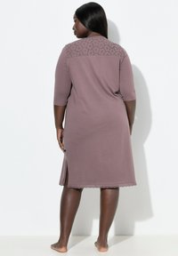 Camicia da notte color mauve polveroso con maniche a tre quarti, dettagli in pizzo sulle spalle, spacchi laterali e orlo a scallop. Tessuto morbido.