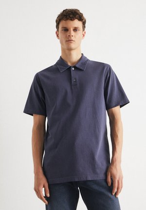 Navy blue cotton polo shirt with short sleeves, a pointed collar, three-button placket, and minimal stitching details. Casual fit.