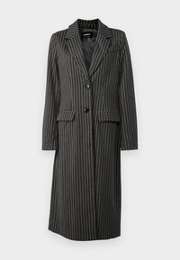 Černý sáčkový dlouhý blejzr s proužky, má klopový límec, dvě přední kapsy a zapínání na knoflíky. Vyrobeno z texturované tkaniny.