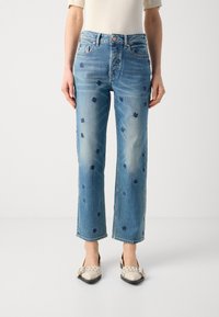 Lys blå rette jeans med broderte mørkeblå blomstermønstre. De har et klassisk fem-lomme-design og knappelukking.