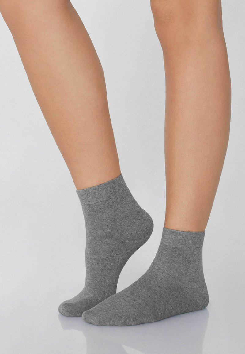 Szare skarpetki za kostkę wykonane z miękkiego materiału o gładkiej fakturze, z żeberkowym mankietem i klasycznym wzornictwem.