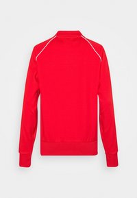 Červená mikina s vysokým límcem, žebrovanými manžetami a lemem. Obsahuje bílé lemování kolem ramen. Vyrobena z hladkého, texturovaného materiálu.