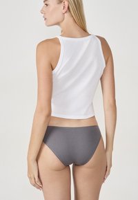 Débardeur court en coton blanc associé à une culotte grise en coton, mettant en valeur une texture lisse et un design simple.