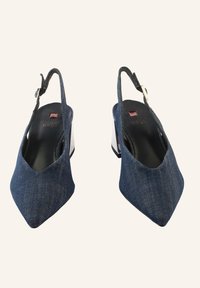 Denimové slingback boty na podpatku s špičatou špičkou a stříbrným blokovým podpatkem. Disponují elegantním designem s tenkým řemínkem kolem kotníku a texturovaným materiálem.