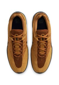 Para brązowych i beżowych sneakersów Nike z czarnymi podeszwami, widzianych z góry, pokazujących sznurówki i oddychającą siateczkę górną.