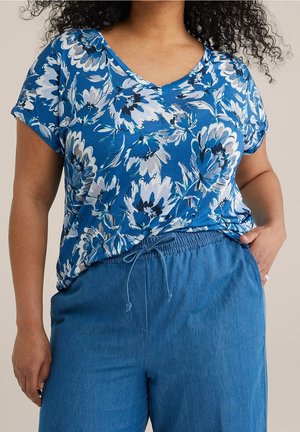 Haut à manches courtes à imprimé floral bleu avec un décolleté en V, associé à un pantalon bleu clair à taille élastique. Tissu lisse avec une coupe décontractée.