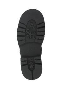 Suola in gomma nera con motivi di presa testurizzati, logo "ASH" a rilievo e dettagli a forma di stella. Superficie liscia con linee di trazione ben definite.