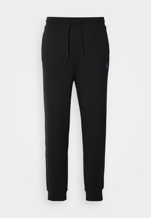 Zwarte sweatpants van zacht materiaal, met een verstelbare tailleband en ribbels aan de boorden. Bevat een klein blauw logo aan de zijkant.