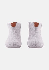Une paire de bottines en feutre gris avec des passants en cuir brun sur un fond blanc, montrées de face.