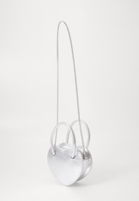 Stříbrná metalická kabelka ve tvaru srdce s dvojitými rukojetmi a řetízkovým popruhem, s hladkým povrchem a minimalistickým designem.