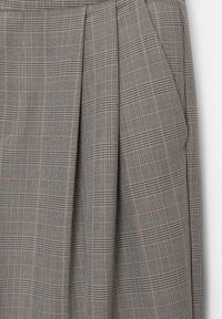 Jupe plissée à carreaux grise avec des accents subtils rouges et bleus, dotée d'un tissu texturé et de deux poches avant.