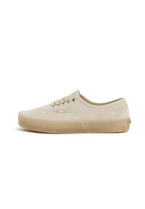 Basket basse beige Vans avec dessus en daim, semelle en gomme naturelle, lacets à l'avant et petit logo latéral et au talon.