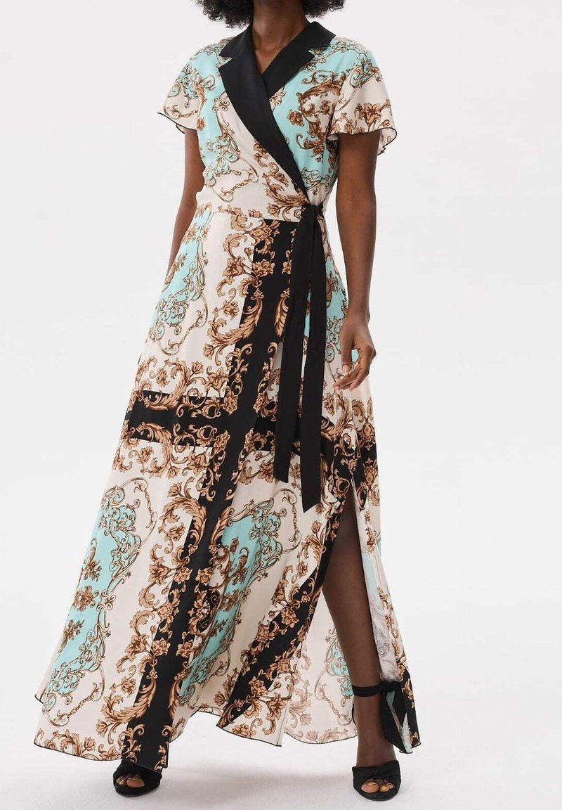 Robe maxi avec une base crème clair ornée d'un motif turquoise et marron, des bordures noires et un design enveloppant avec une fente haute jusqu'à la cuisse.