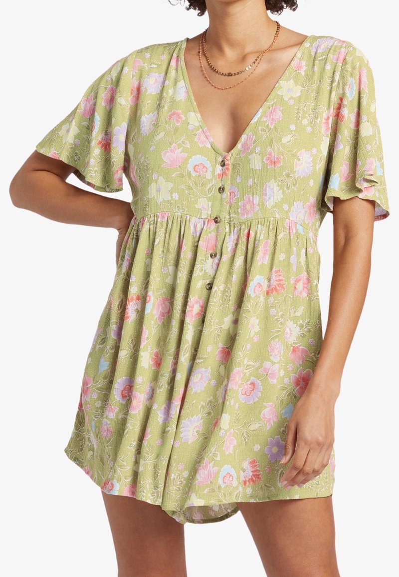 Grön blomklänning med V-ringning, korta fladdriga ärmar och knäppning framtill. Har rosa och blå blomsterblad på ett texturerat tyg.