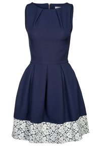 Robe bleu marine sans manches avec col rond, taille cintrée, jupe évasée et détail de dentelle florale blanche à l'ourlet.