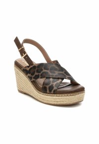 Sandalo con zeppa leopardato con cinturini incrociati, dettagli in pelle marrone e suola in juta intrecciata. Cinturino regolabile con chiusura a fibbia.