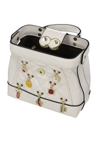 Bolso blanco acolchado con herrajes dorados, con detalles de charms como una mariquita y una cara sonriente. Diseño de apertura superior con un pequeño asa.