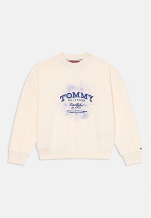 Krémszínű pulóver kék virágmintával és "Tommy Hilfiger 1985-ben alapítva" felirattal az elején.