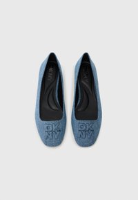 Denim ballet flats in light blue with a rounded toe, embossed DKNY logo on the front, and black inner lining for comfort.
