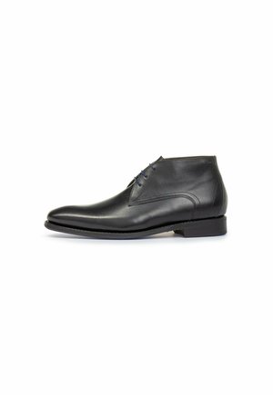 Botas de tobillo de cuero negro con un acabado suave, punta afilada y cordones azules. Diseñadas con un tacón bajo y sutiles detalles de costura.