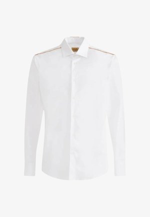 Camicia bianca a maniche lunghe con bottoni e colletto classico, con cuciture marroni sottili lungo le cuciture delle spalle.